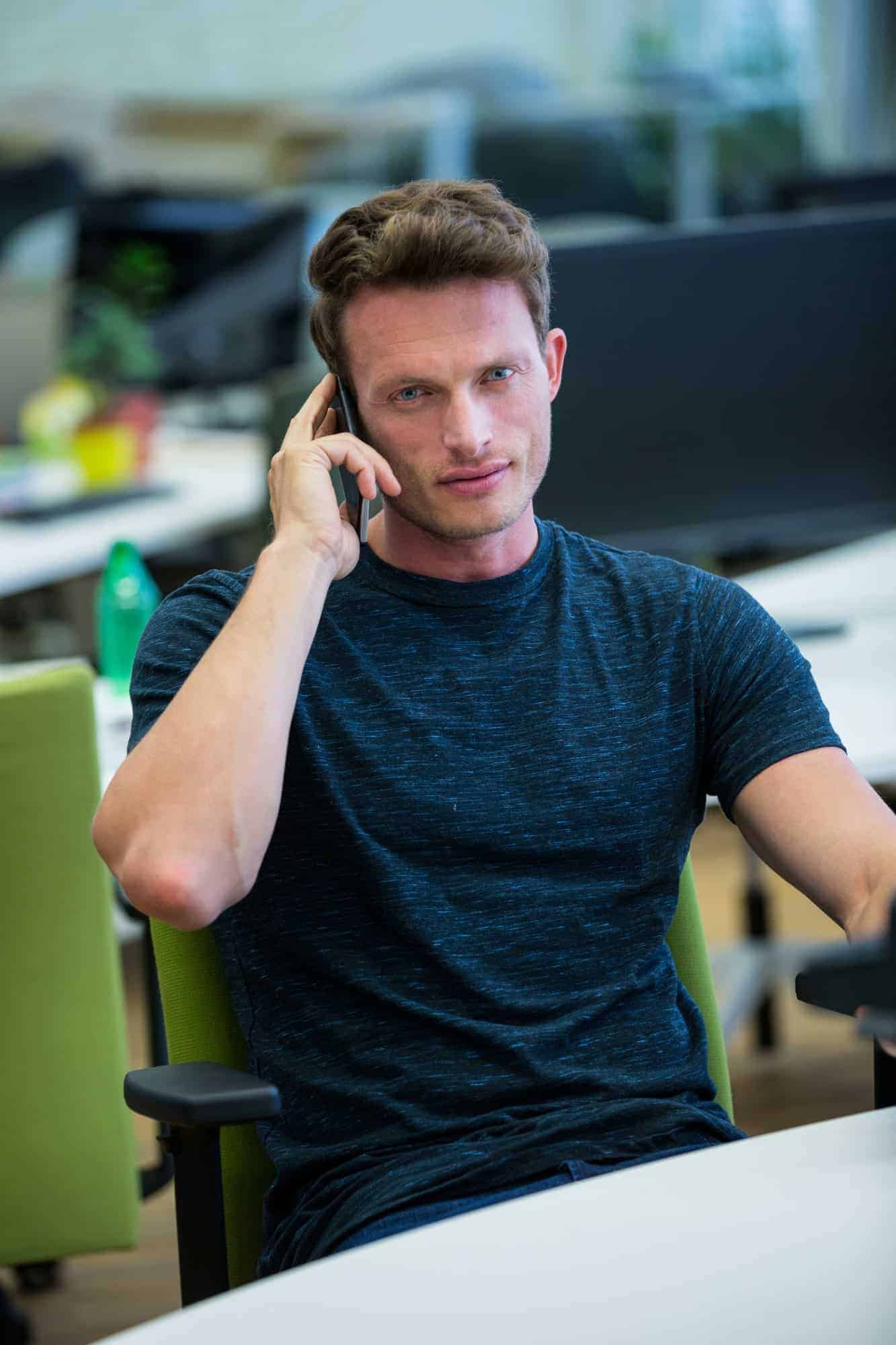 male business executive talking on mobile phone in office