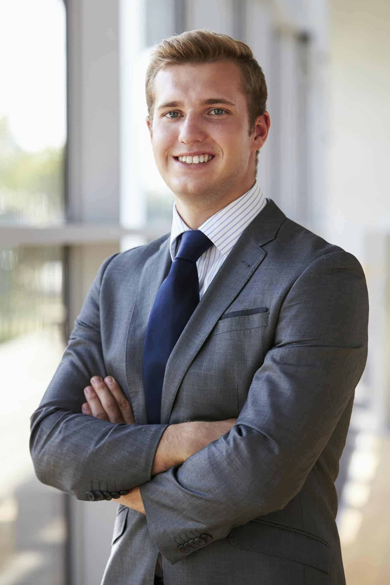 portrait of a young smiling professional man arms crossed