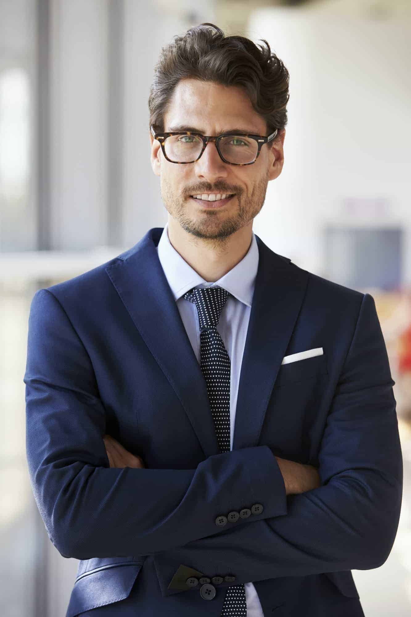 portrait of young professional man in suit arms crossed